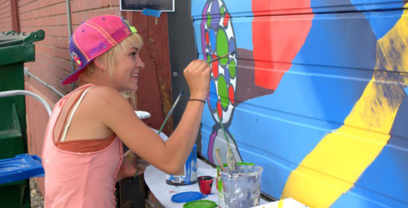 an artist paints a mural on a garage door