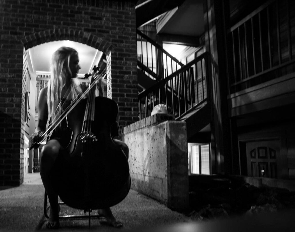 A black and white photo of a woman playing cello