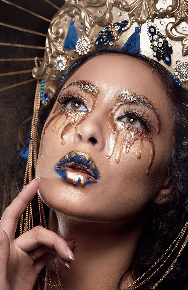 A woman with gold paint tears and lips