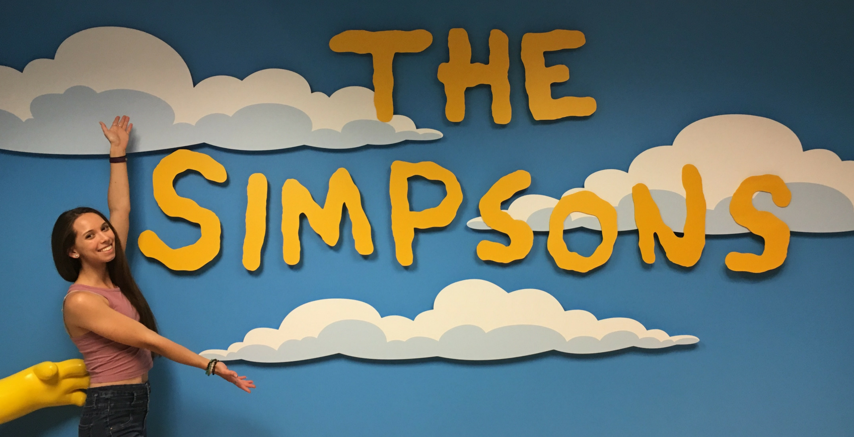 Chloe Dejong posing in front of The Simpsons installation