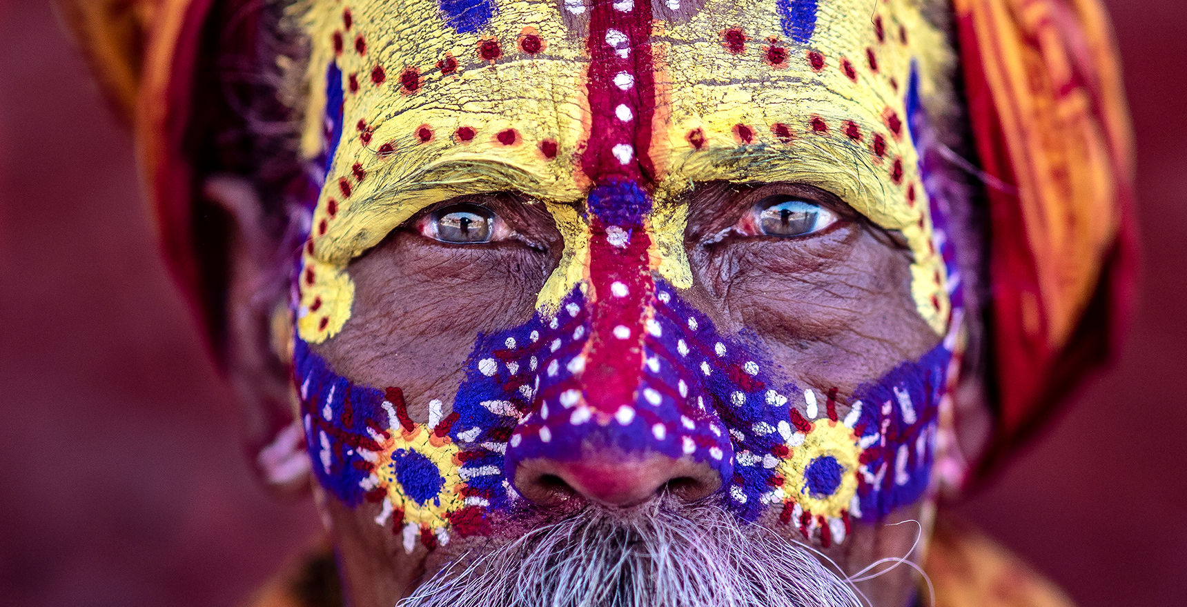 Close up photo of a man's face painted colorfully