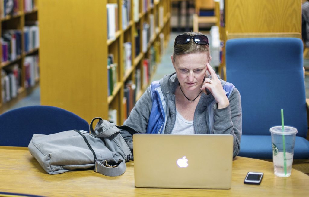 RMCAD student sitting at table in library