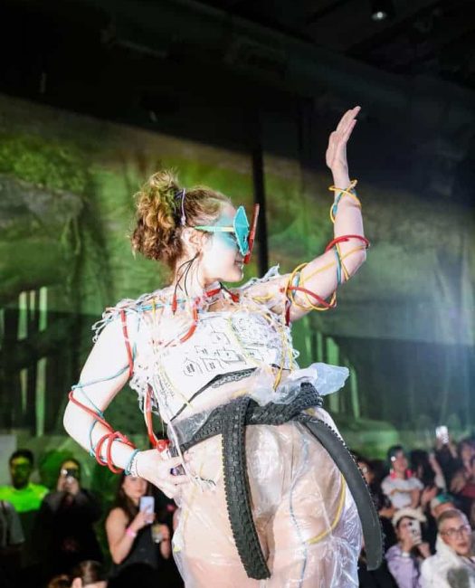 Model posing on the runway of Meow Wolf's fashion show